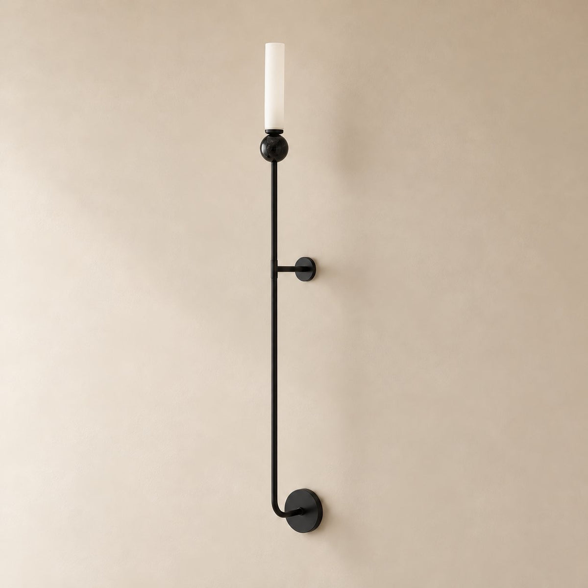 Aljezur vertical marble wall sconce in black with black marble, Model A (36 cm), unlit, shown close on a plaster wall.
