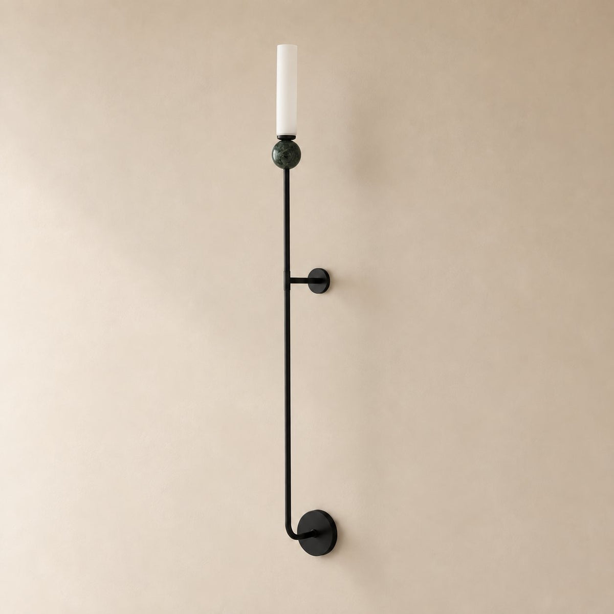Aljezur vertical marble wall sconce in black with green marble, Model A (36 cm), unlit, shown close on a plaster wall.