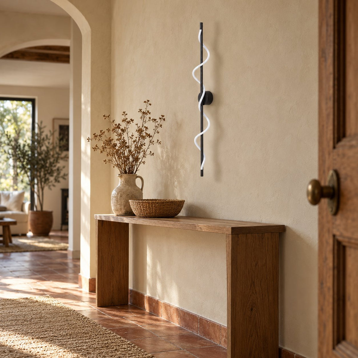 Alvito black linear sconce with wavy light above a console table in an entryway.
