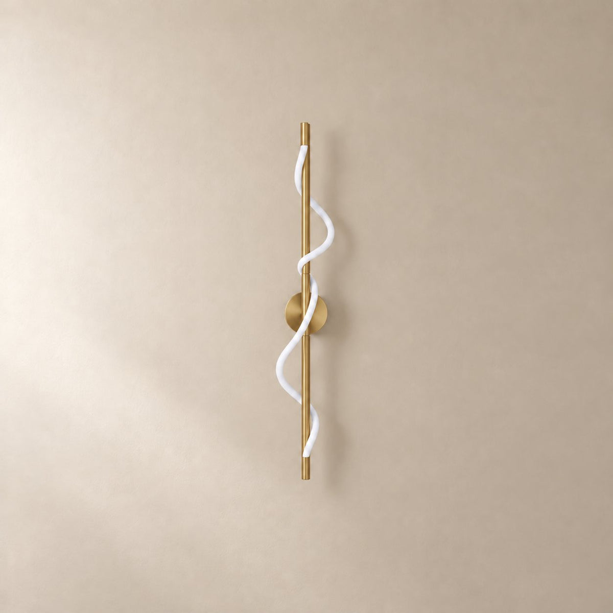 Alvito linear flexible wall sconce in brushed brass, 90 cm, unlit on a plain plaster wall.