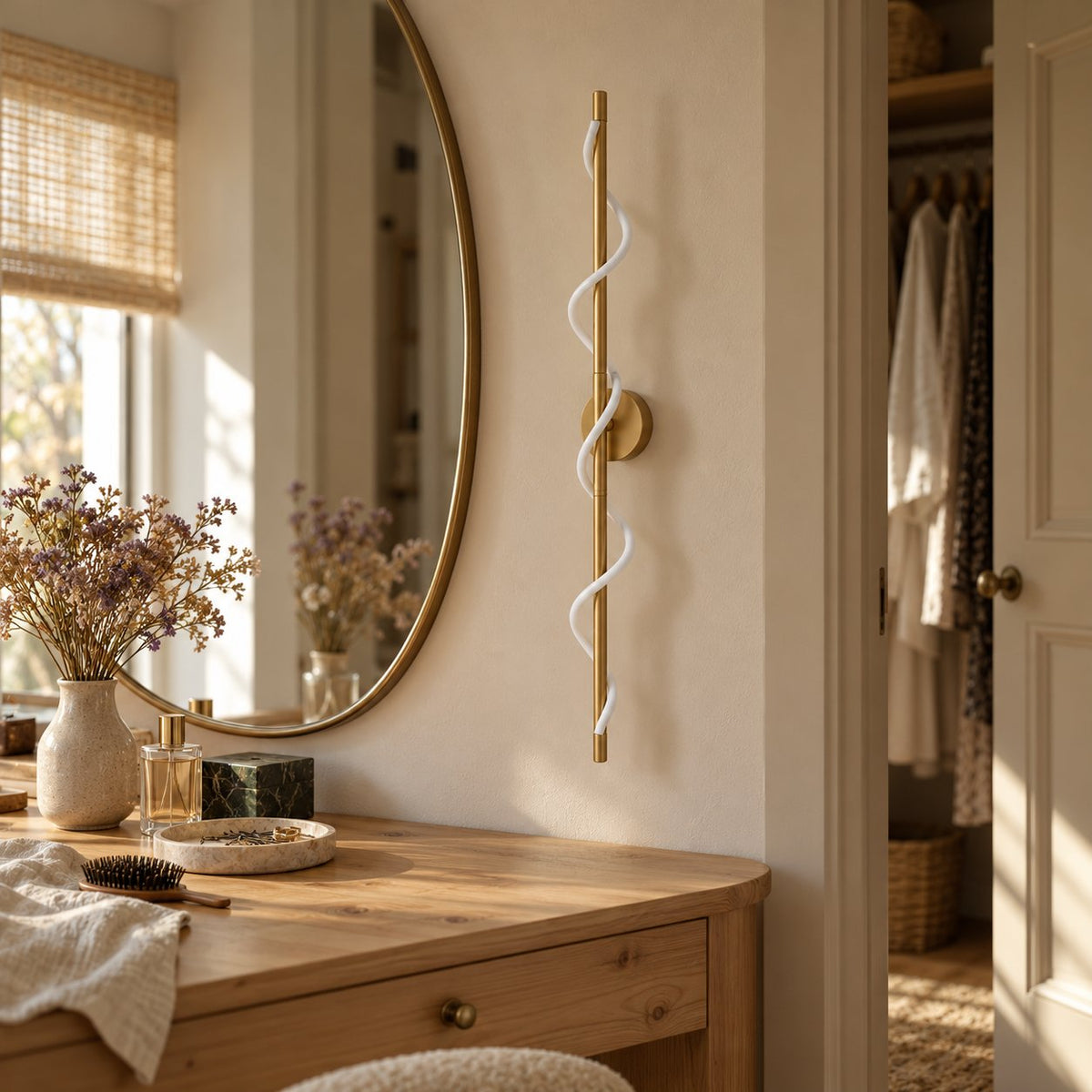 Alvito brass linear sconce with wavy light beside a bedroom vanity mirror.
