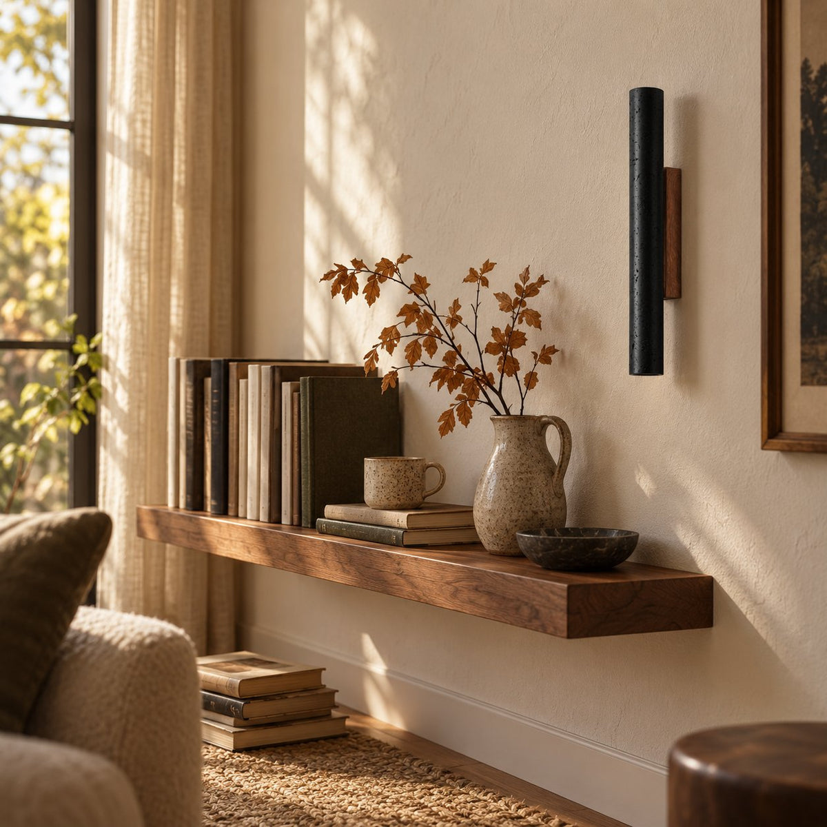 Arraiolos black travertine wall sconce with walnut back above a floating bookshelf.