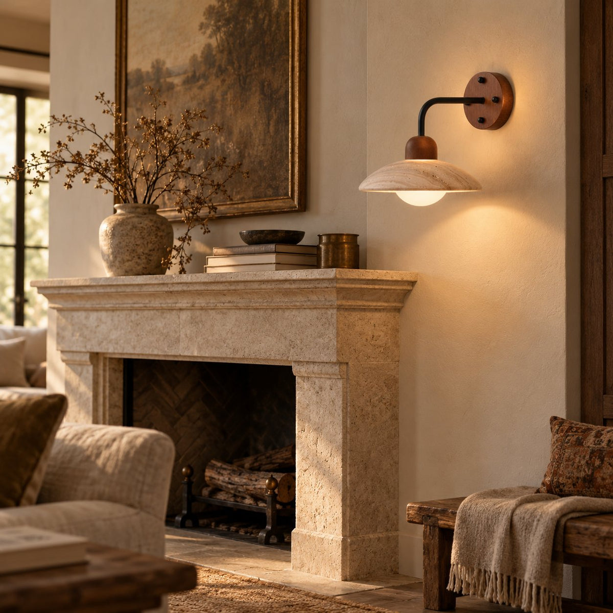 Boticas travertine dome arm sconce glowing warmly beside a stone fireplace mantel.