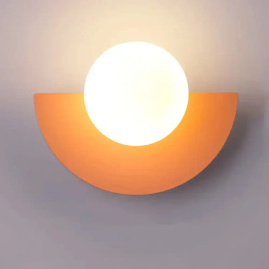 Cleo semicircle globe wall sconce in pink with warm light