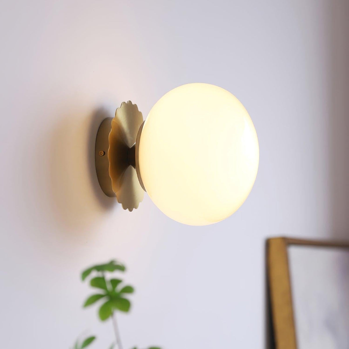 Close-up detail of gold metal structure and white tinted glass diffuser