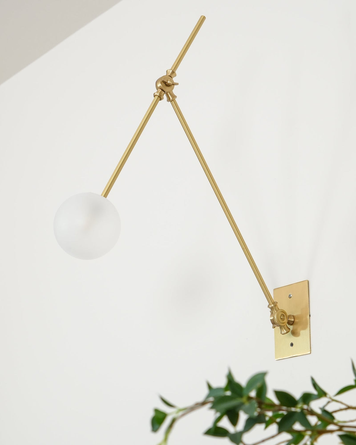 Lifestyle shot of sconce providing reading light over chair