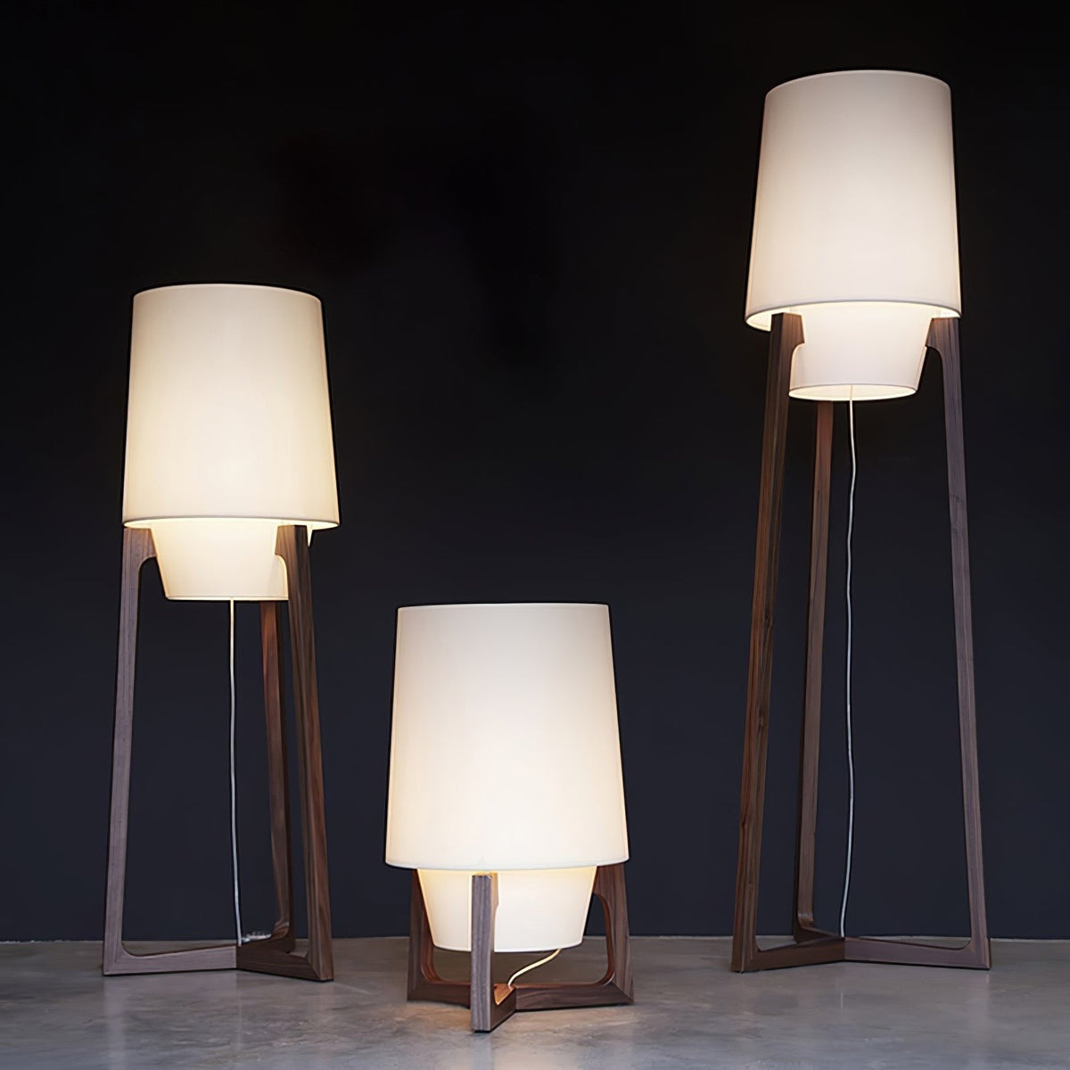Morros floor lamps, three heights lit in a dark room