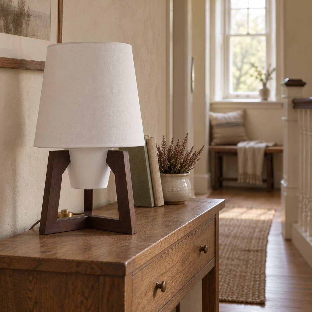 Morros small tripod linen table lamp in black walnut on a low oak cabinet on an upstairs landing.