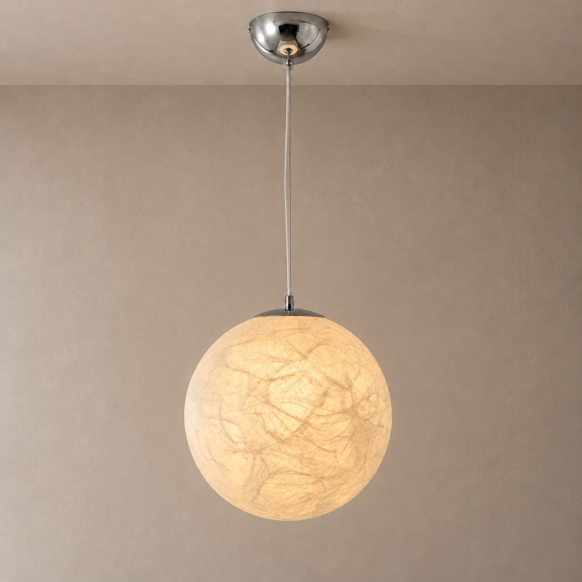 Mulberry Silk Globe Pendant Light in Chrome illuminated against a warm taupe wall with extended suspension cable