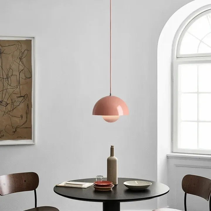 Nola pink mushroom pendant light above a dining table beside an arched window