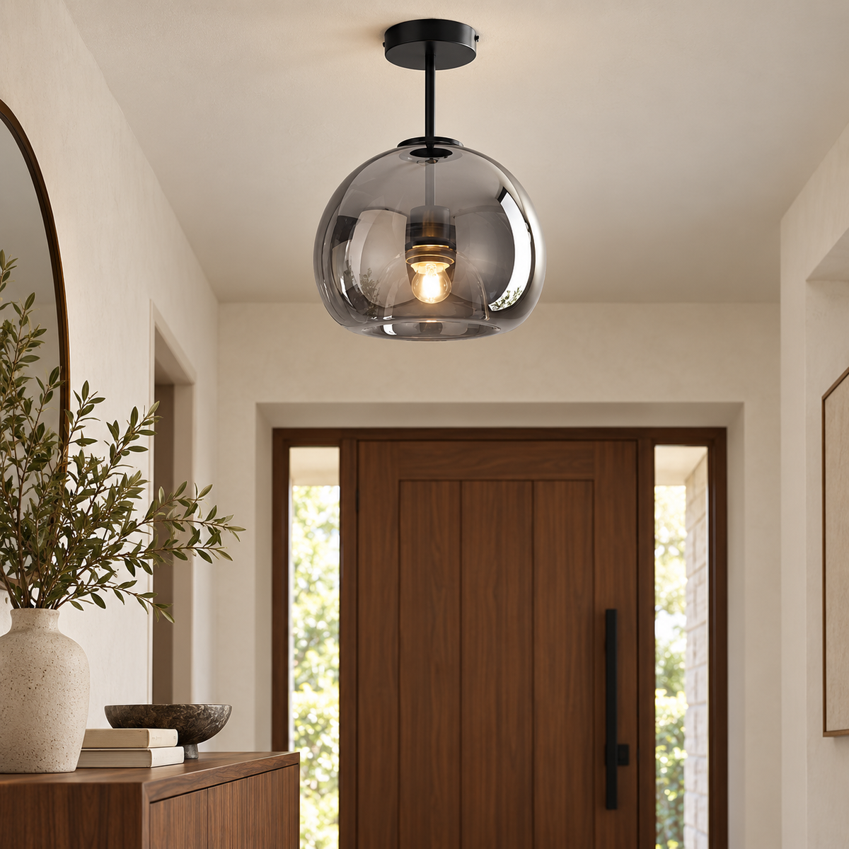 Oren smoke-gray glass ceiling light with black hardware above a walnut console in a modern entryway