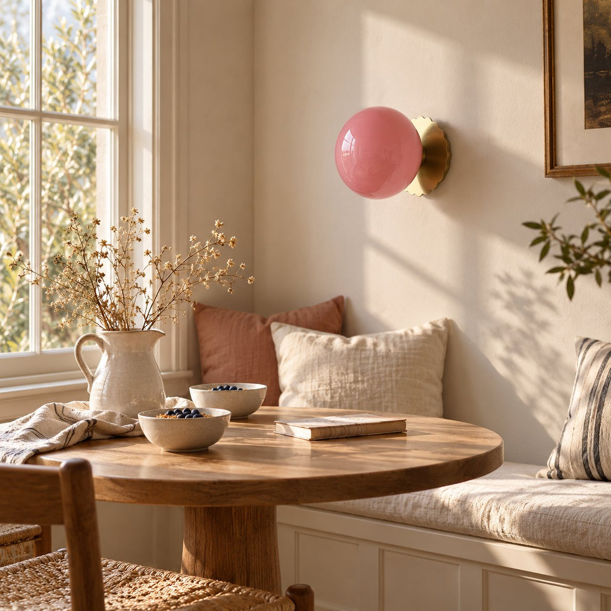Tâmega convertible wall sconce with pink glass above a round table in a breakfast nook.