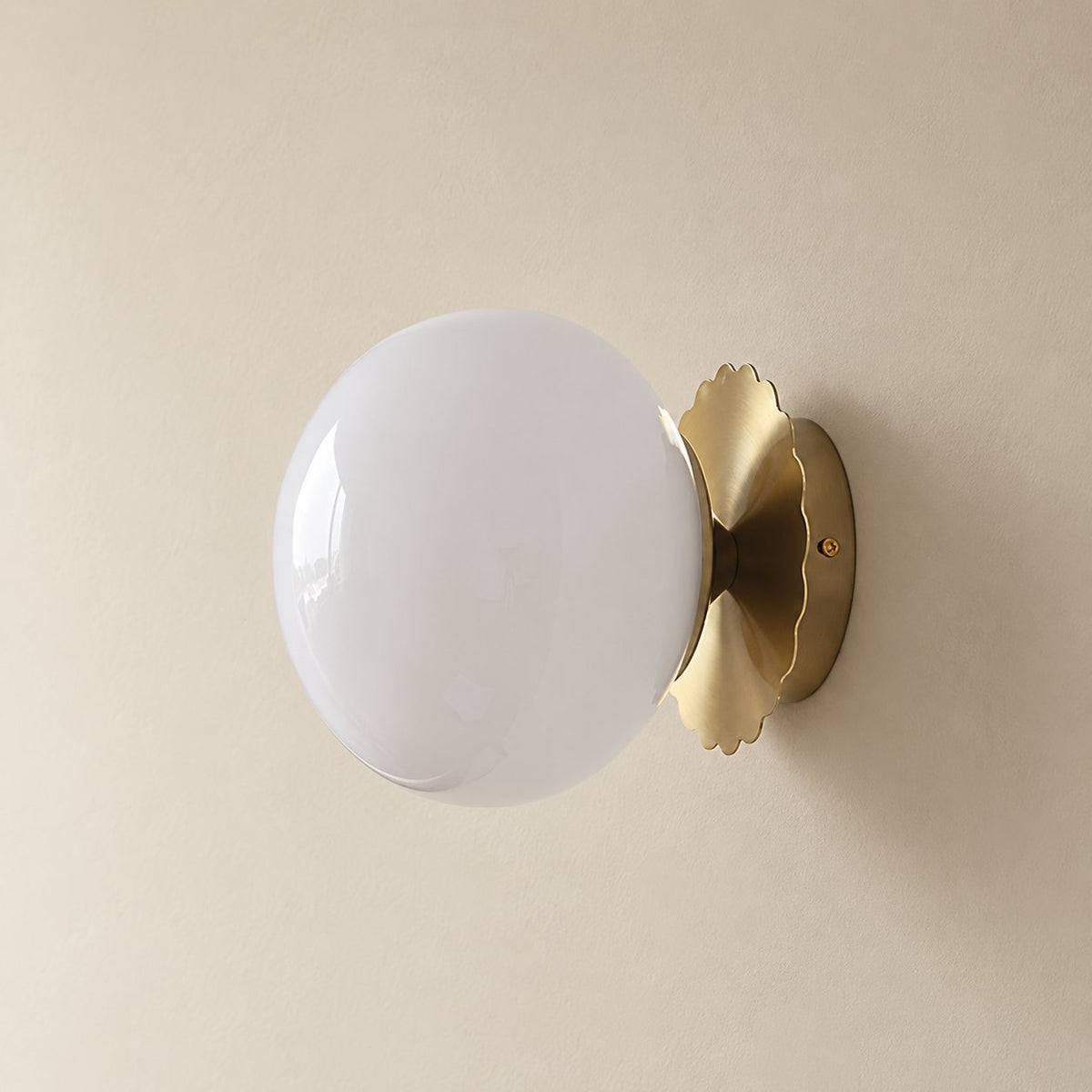 Tâmega convertible wall sconce in gold and white, unlit on a plain plaster wall.