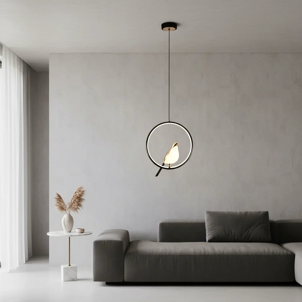 Black ring bird pendant hanging above a dark gray sofa in a pale gray living room
