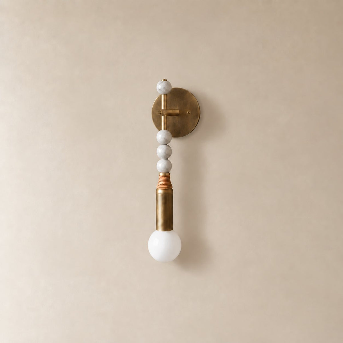 Torto marble wall sconce in antique brass and white marble, Short (48 cm), unlit on a plain plaster wall.