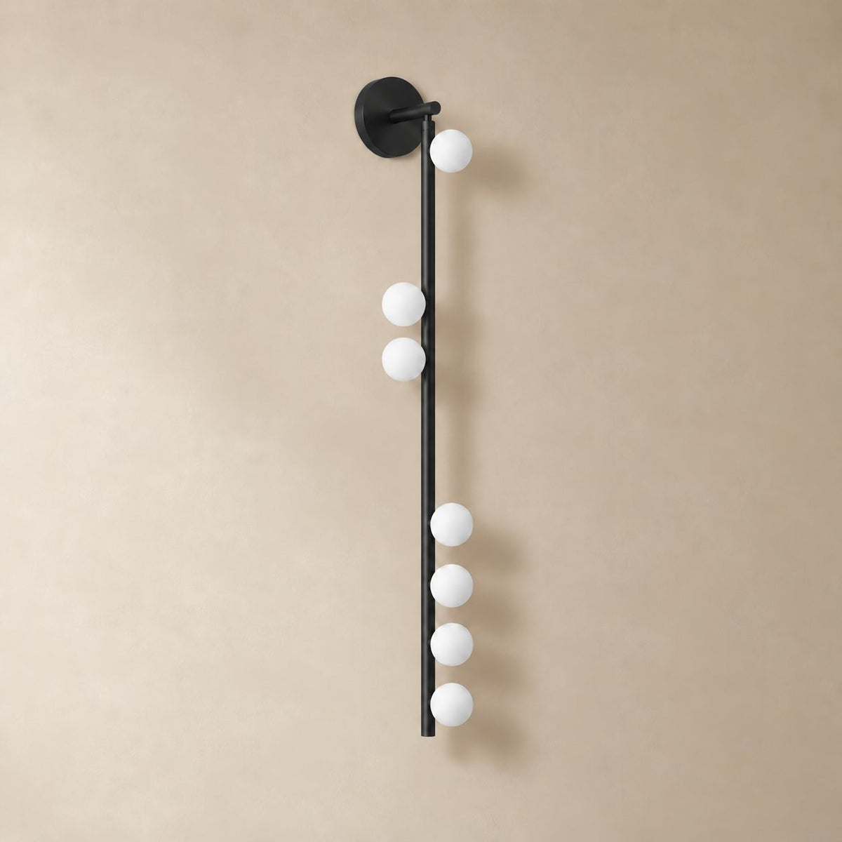 Vouga glass tube wall sconce in matte black, 7 heads A, 100 cm, unlit on a plain plaster wall.