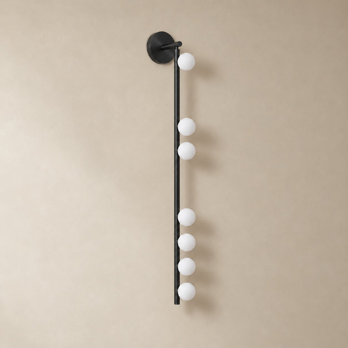 Vouga glass tube wall sconce in matte black, 7 heads B, 100 cm, unlit on a plain plaster wall.