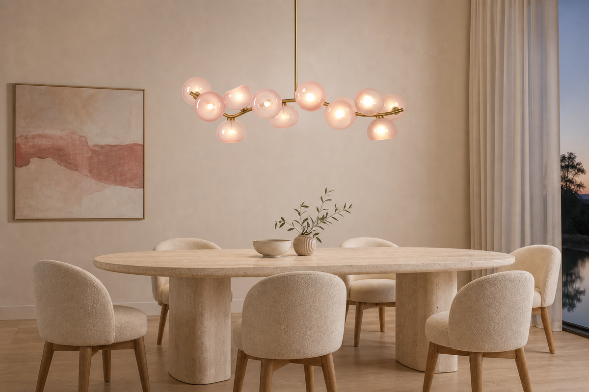 Blush glass 13-light linear chandelier illuminated above a modern travertine dining table