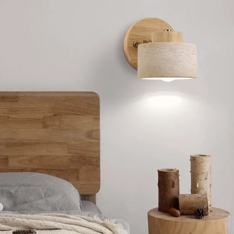 Stone wall light with log wood arm above a bed headboard, lit