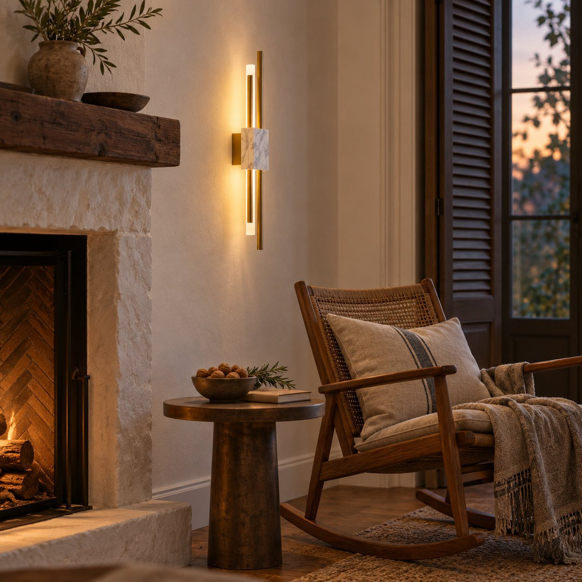 Alcochete gold and white marble wall sconce beside a stone fireplace and a rocking chair.