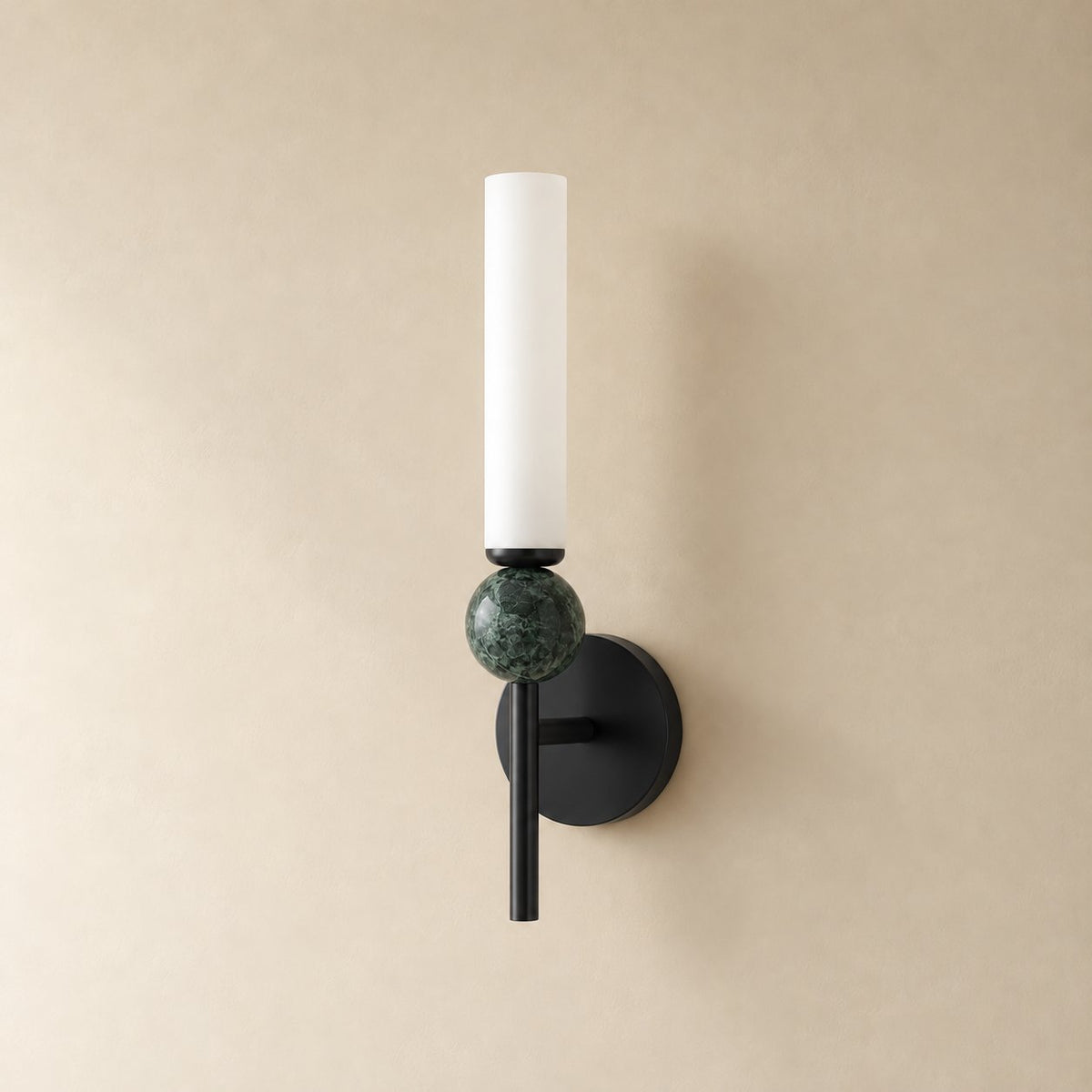 Aljezur vertical marble wall sconce in black with green marble, Model B (38.5 cm), unlit on a plain plaster wall.