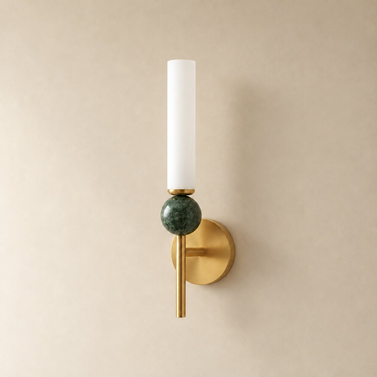 Aljezur vertical marble wall sconce in brass with green marble, Model B (38.5 cm), unlit on a plain plaster wall.
