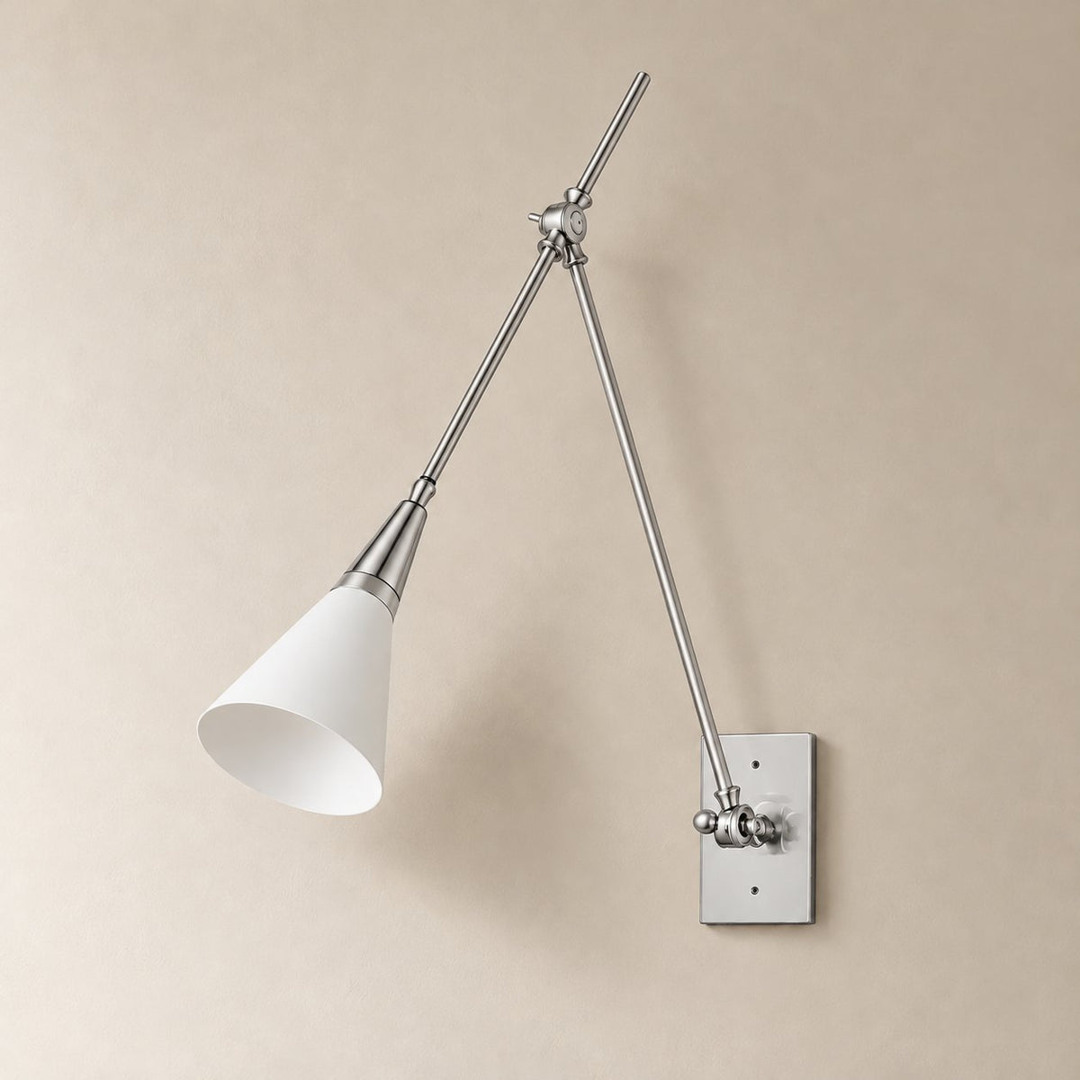 Almodôvar adjustable swing arm sconce in white and bright nickel, unlit on a plain plaster wall.