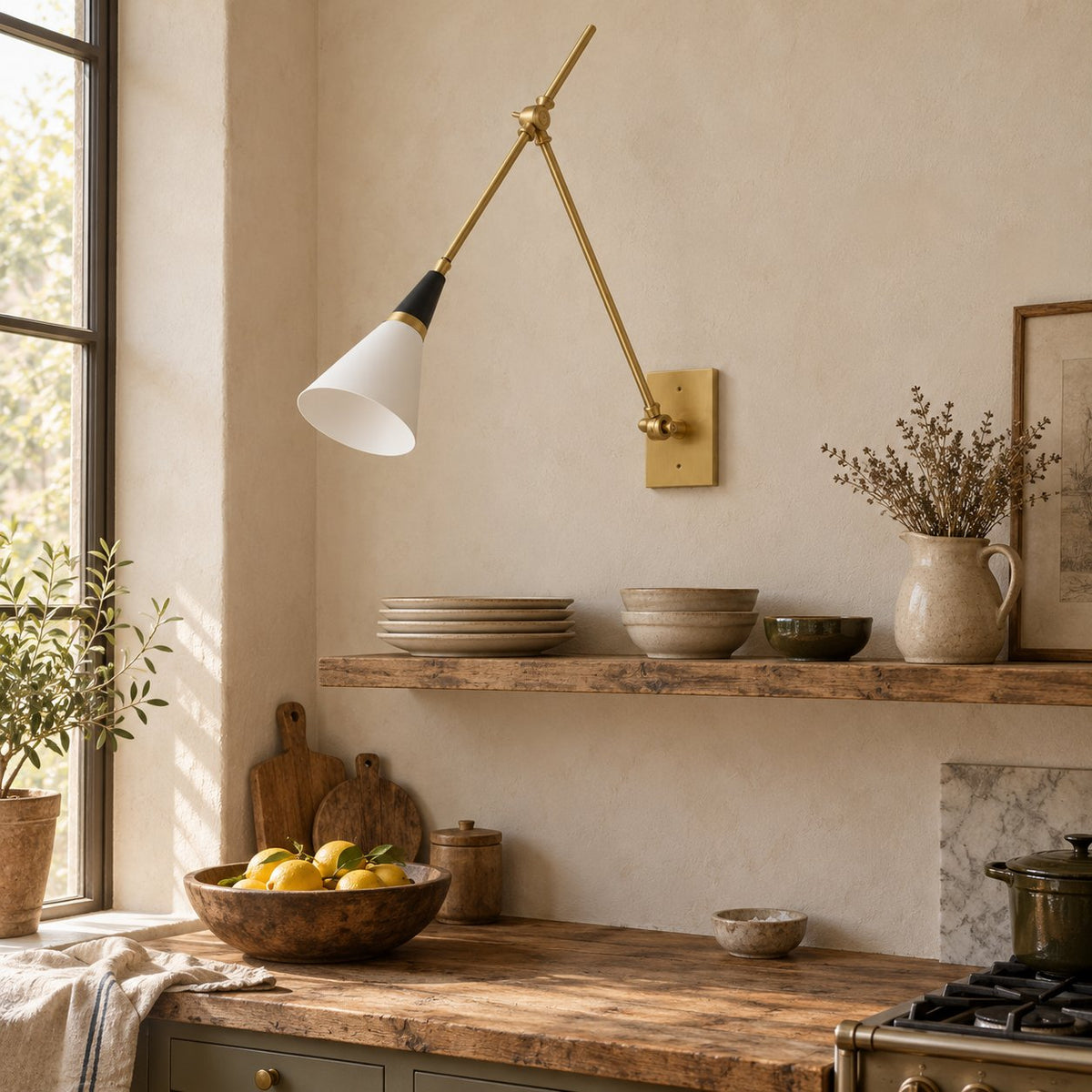 Almodôvar brass swing arm sconce with a white and black cone shade above a kitchen open shelf.
