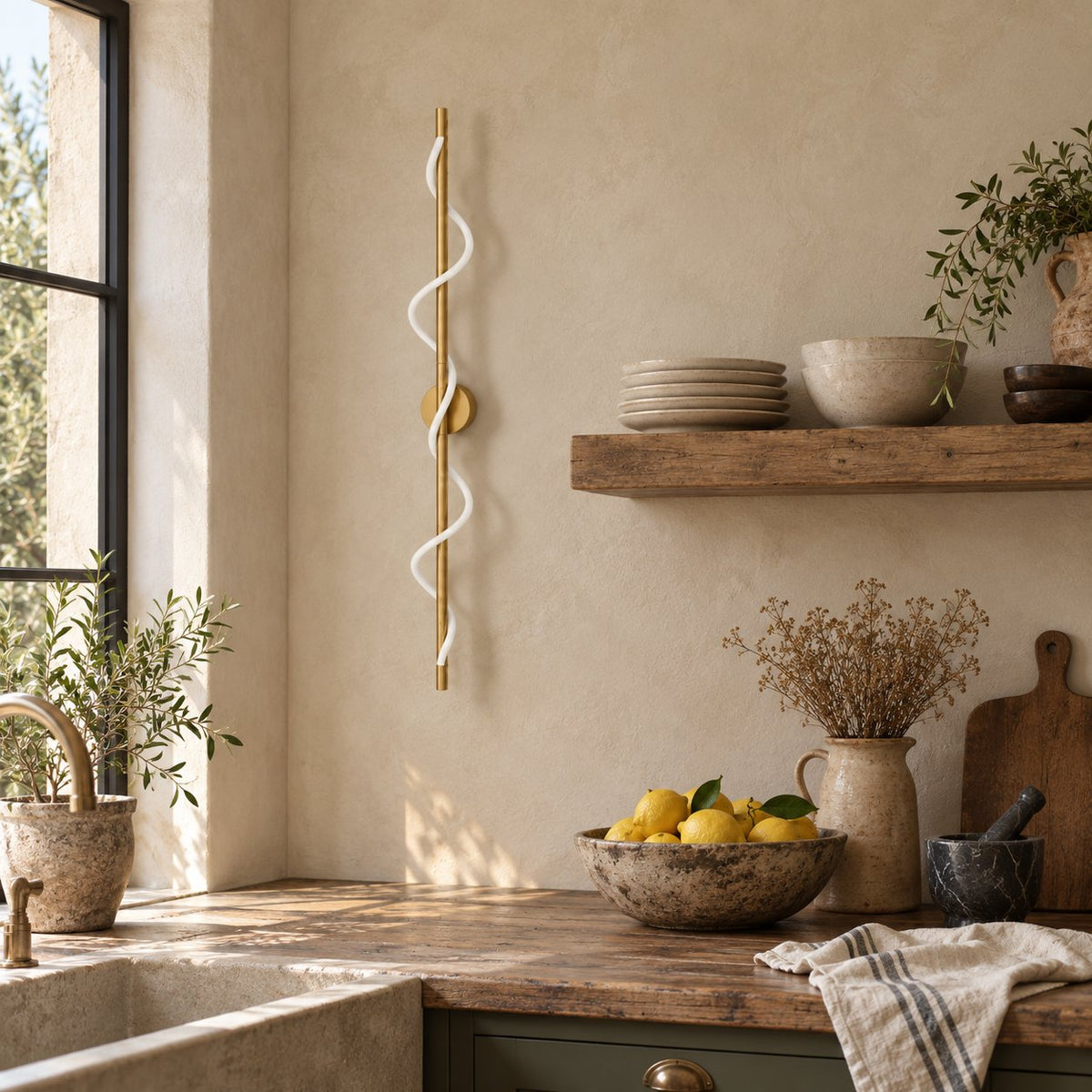 Alvito brass linear sconce with wavy light beside open kitchen shelving.