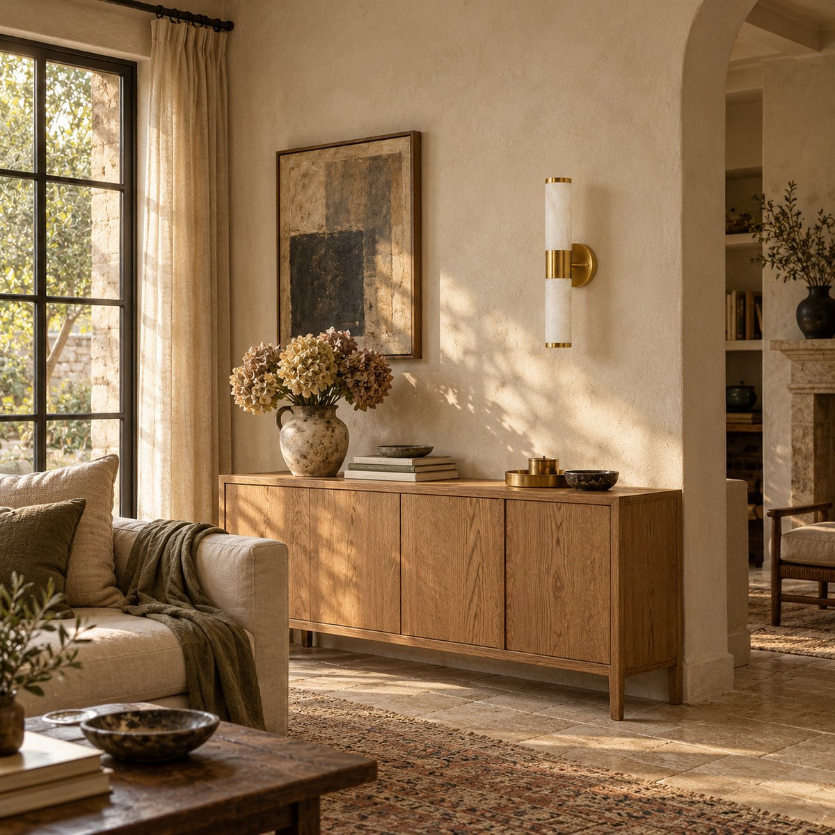Beja alabaster wall sconce with a brass center band above an oak sideboard in a living room.