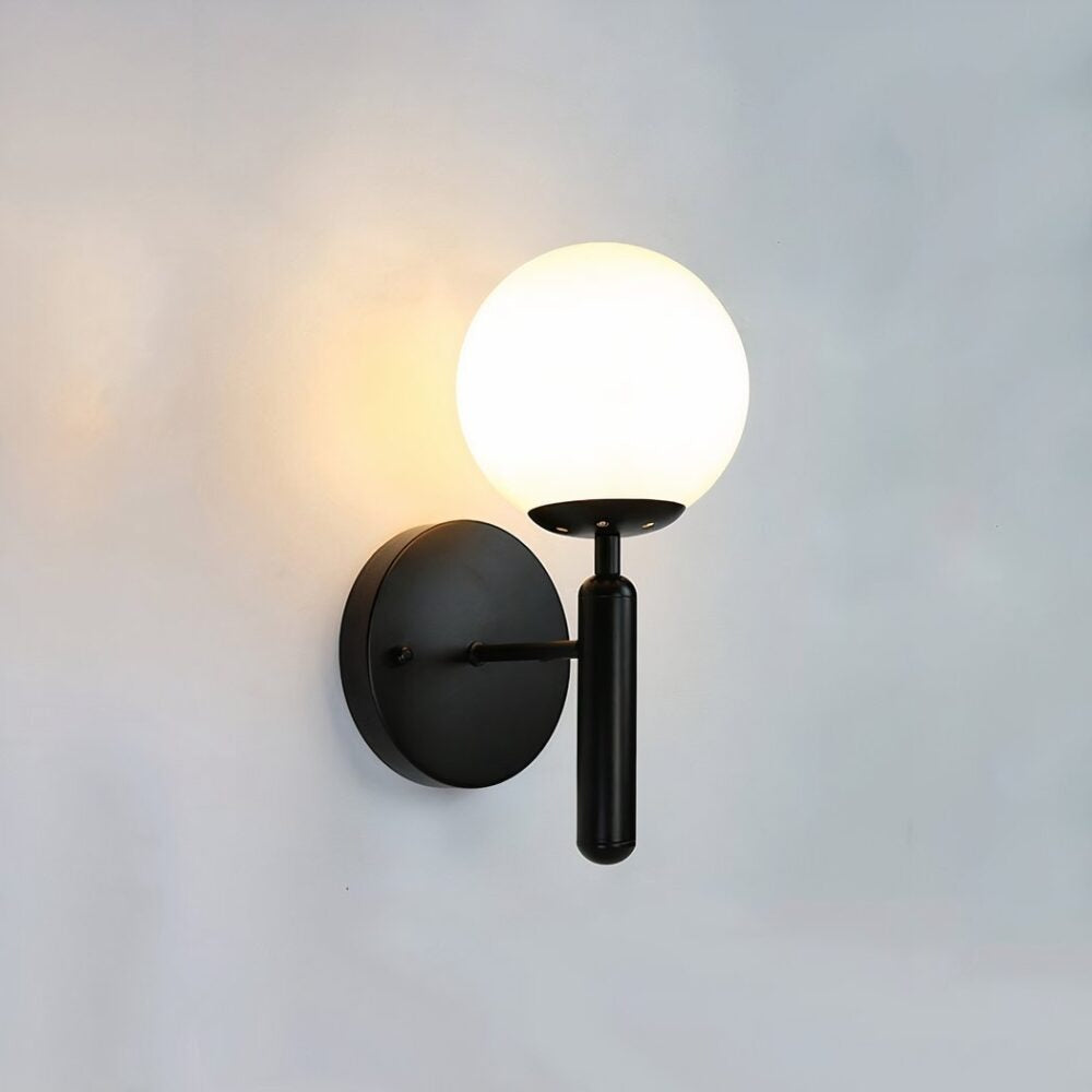 Elio globe wall sconce in black with a white globe shade