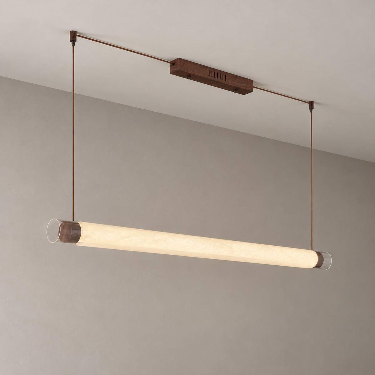 Wood-tone tube pendant illuminated, angled installation view