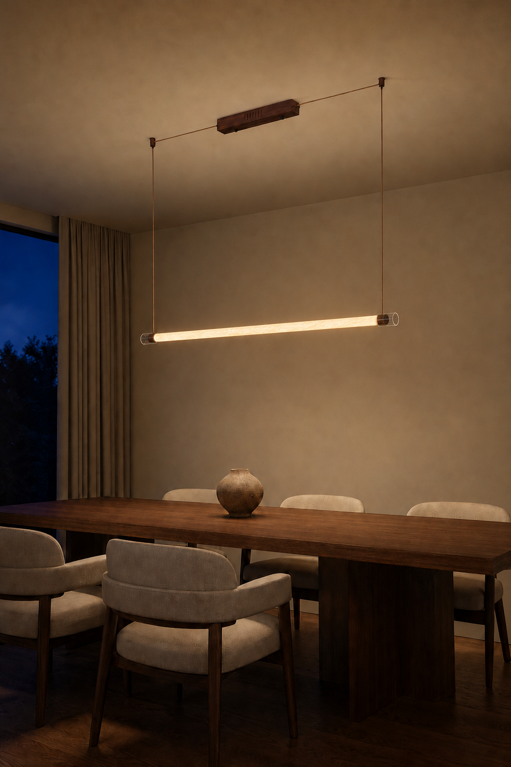 Wood-tone natural-silk tube pendant glowing above an evening dining table