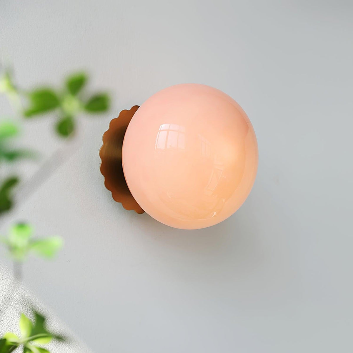 Marshmallow sconce mounted on wall, casting soft light through white glass diffuser