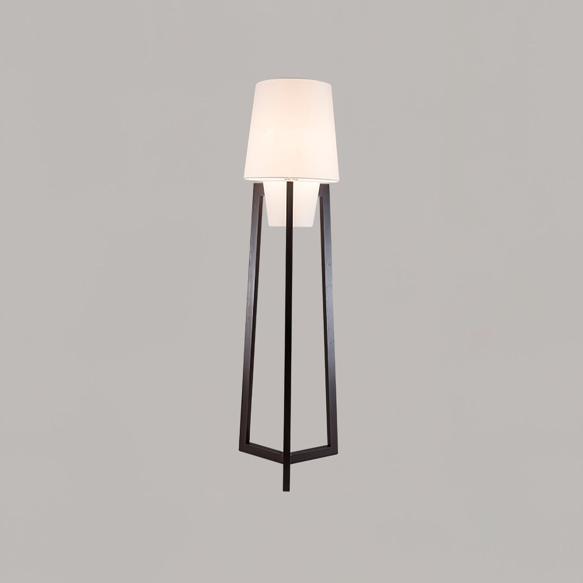 Morros floor lamp lit against a grey wall, front view