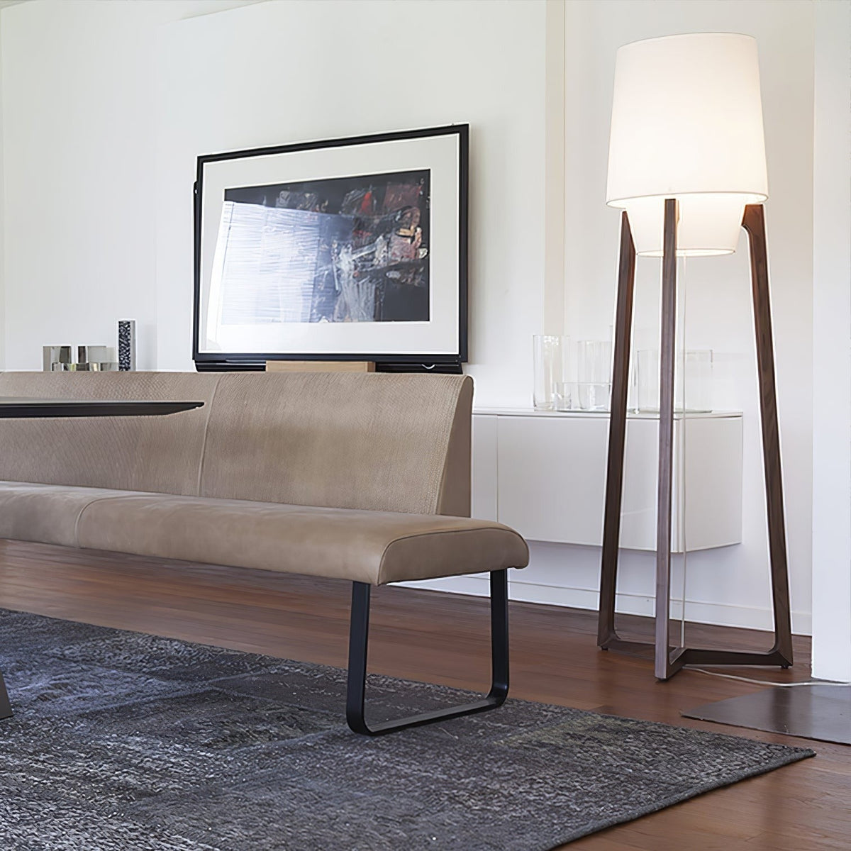 Morros floor lamp lit beside a bench and a framed print