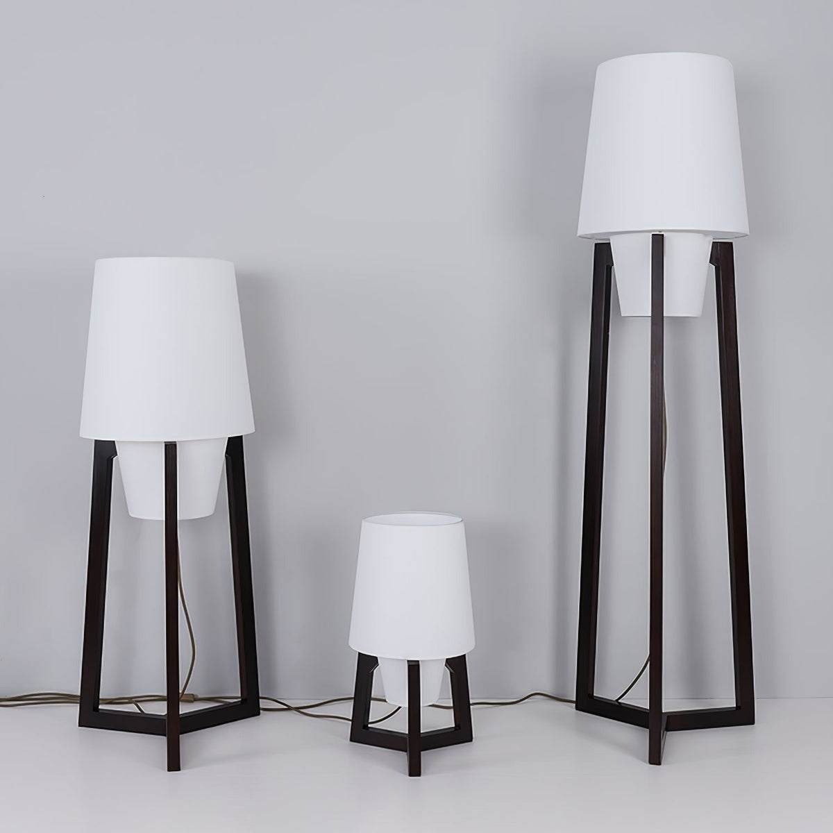 Morros floor lamps, three heights lit side by side against a pale wall
