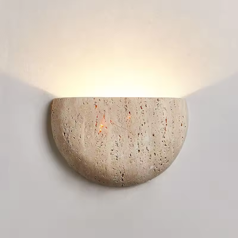 Sora travertine wall sconce illuminated on a neutral wall