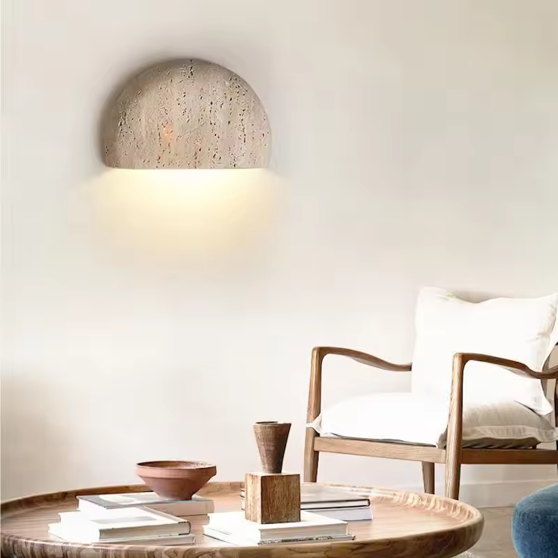Sora half-moon travertine wall sconce in a living room