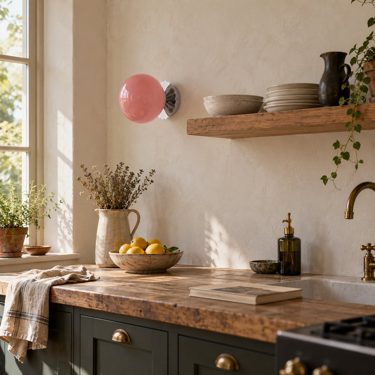 Tâmega convertible wall sconce in chrome with pink glass above a timber kitchen counter and an open shelf.