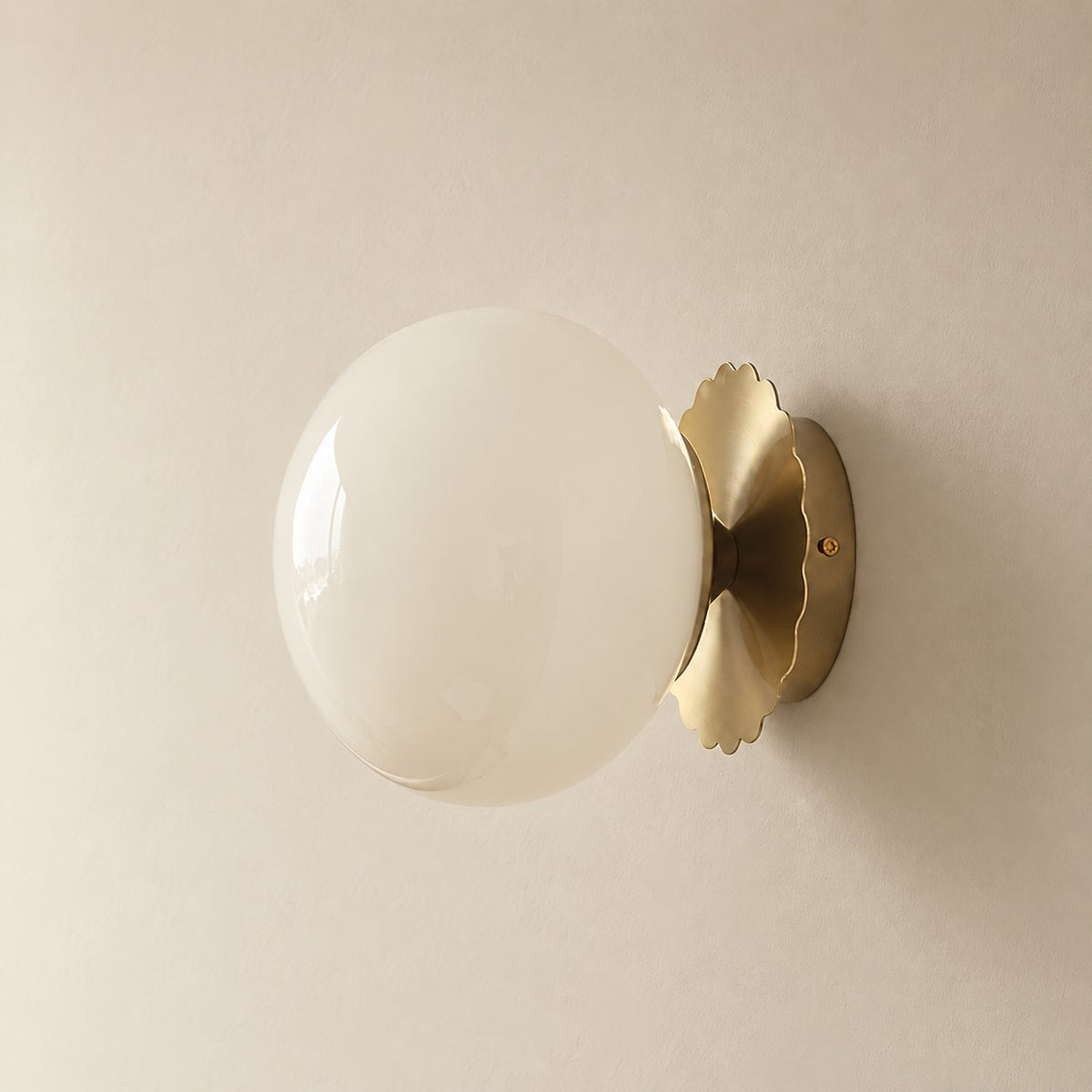 Tâmega convertible wall sconce in gold and beige, unlit on a plain plaster wall.