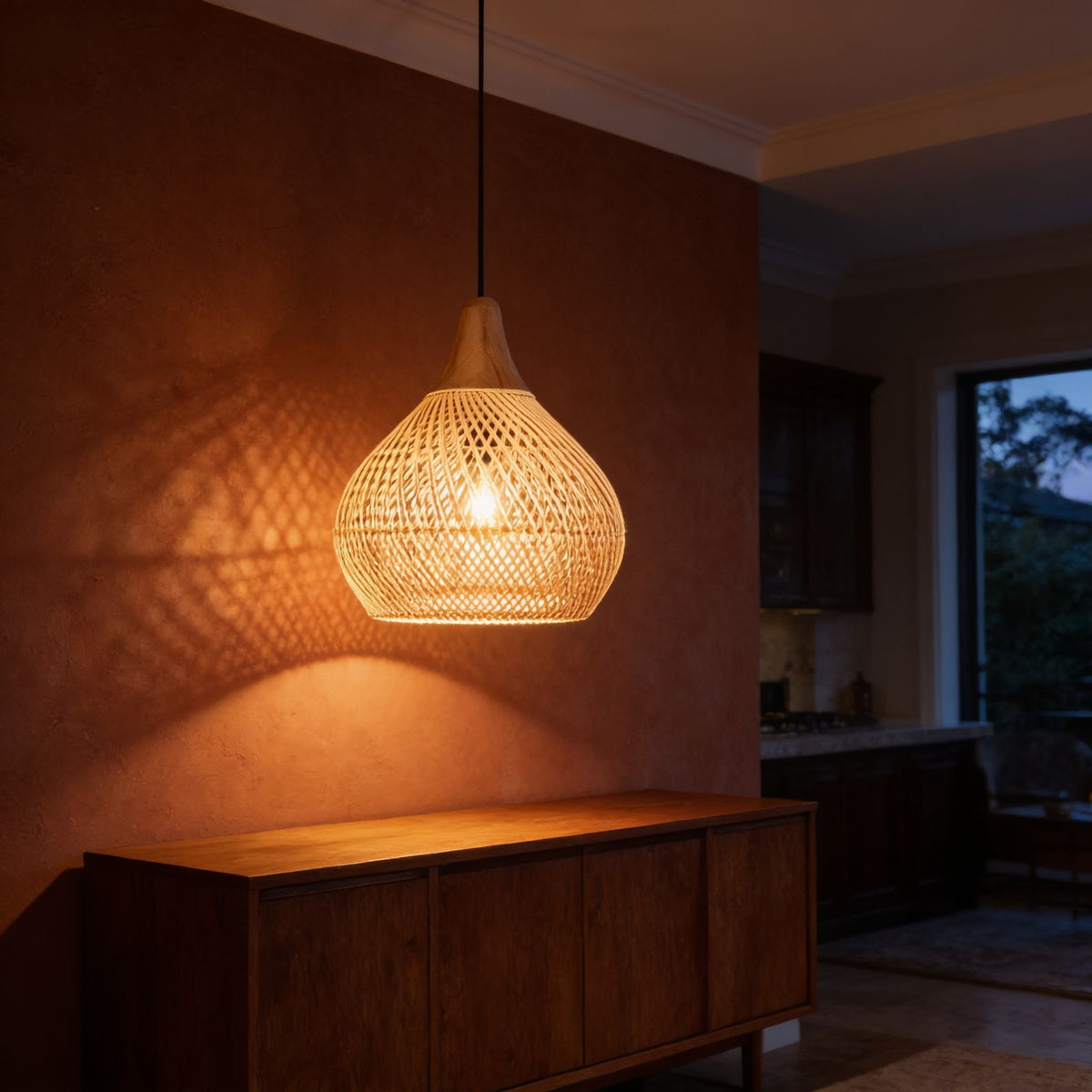 Teardrop Woven Rattan Pendant Light glowing against a plaster wall at night