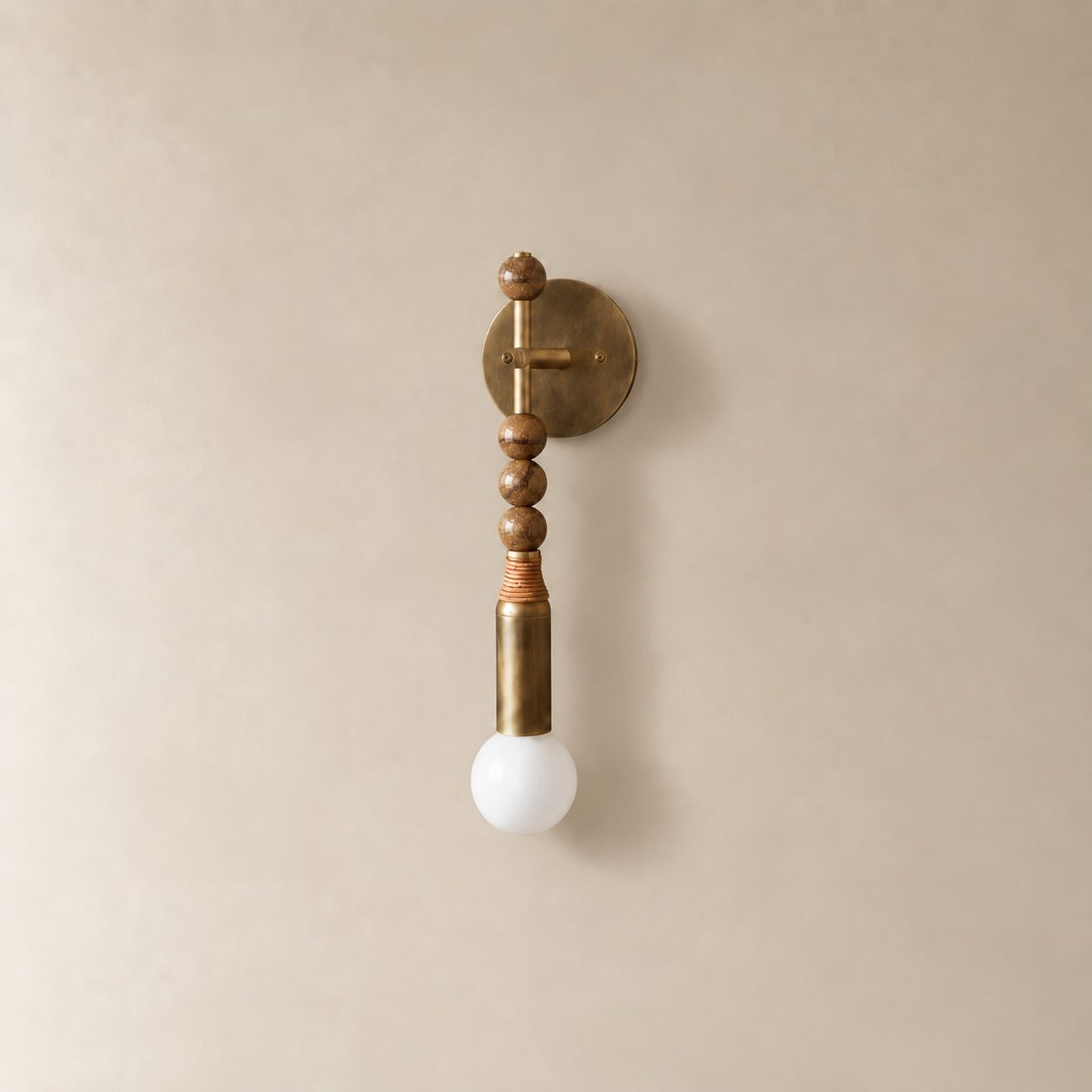 Torto marble wall sconce in antique brass and brown picture jasper, Short (48 cm), unlit on a plain plaster wall.