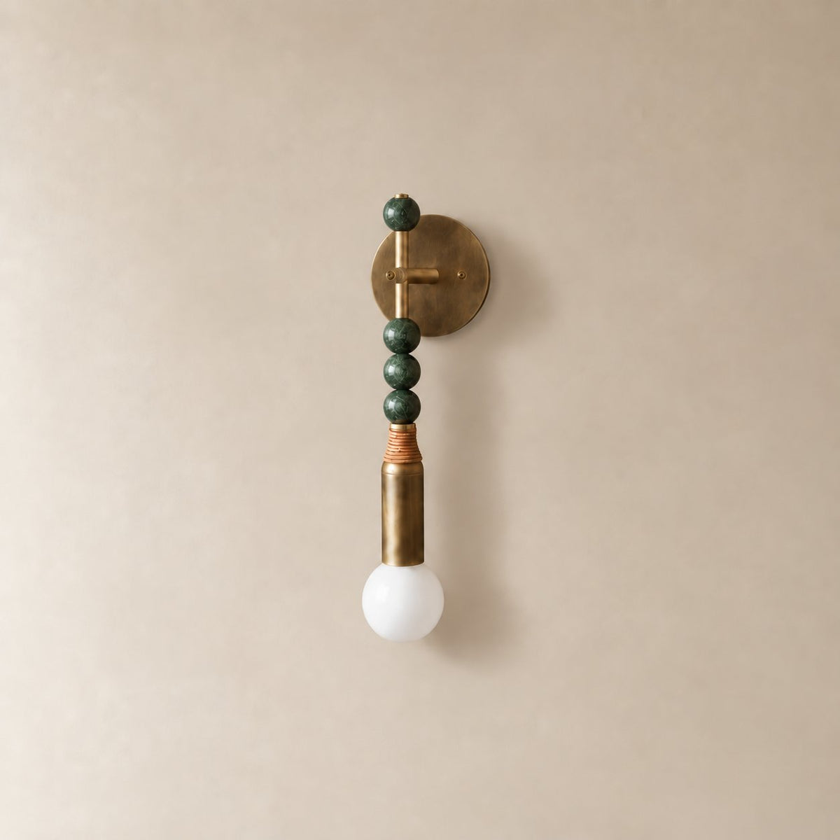 Torto marble wall sconce in antique brass and green marble, Short (48 cm), unlit on a plain plaster wall.