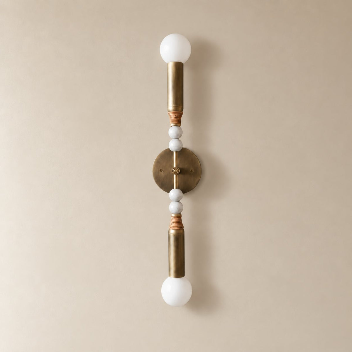 Torto marble wall sconce in antique brass and white marble, Tall (70 cm), unlit on a plain plaster wall.