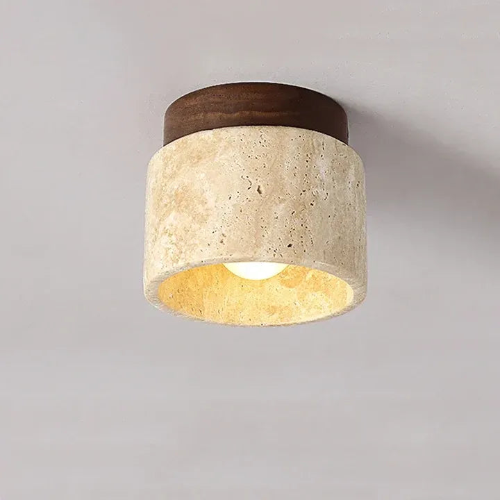 Front view of the Tova travertine ceiling light with a warm glow