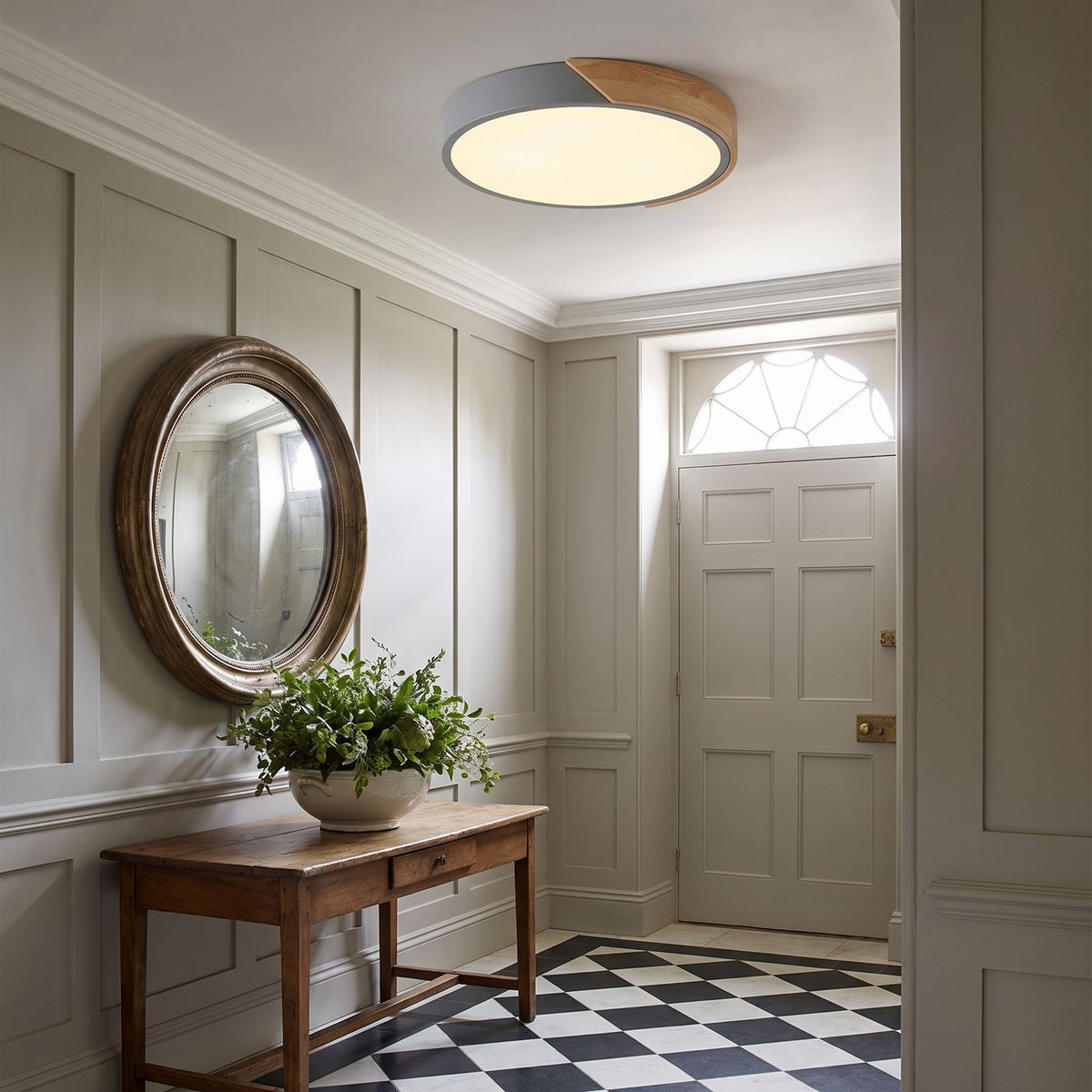 Grey ultra thin LED oyster ceiling light in the entry hall of a classic home
