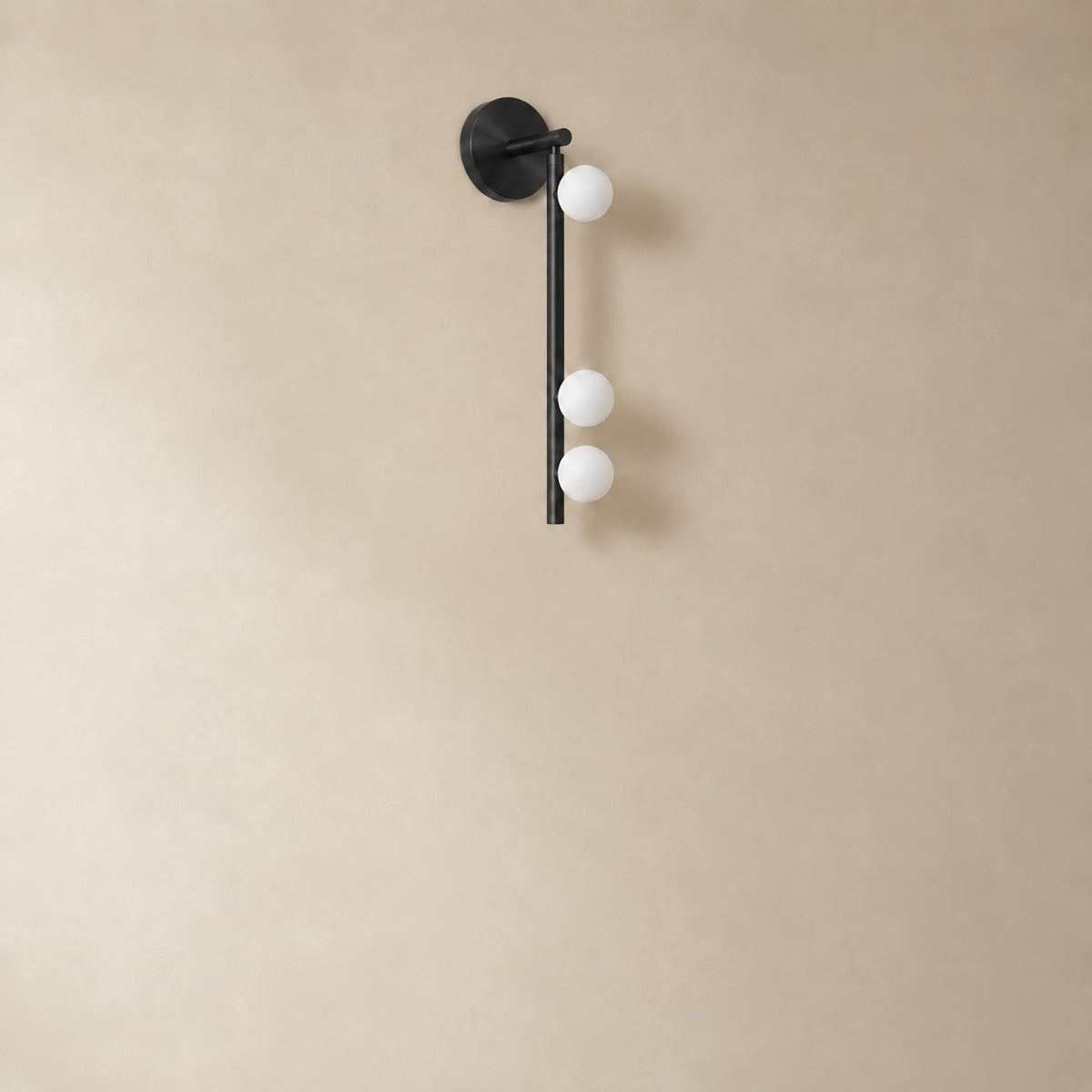 Vouga glass tube wall sconce in matte black, 3 heads, 50 cm, unlit on a plain plaster wall.