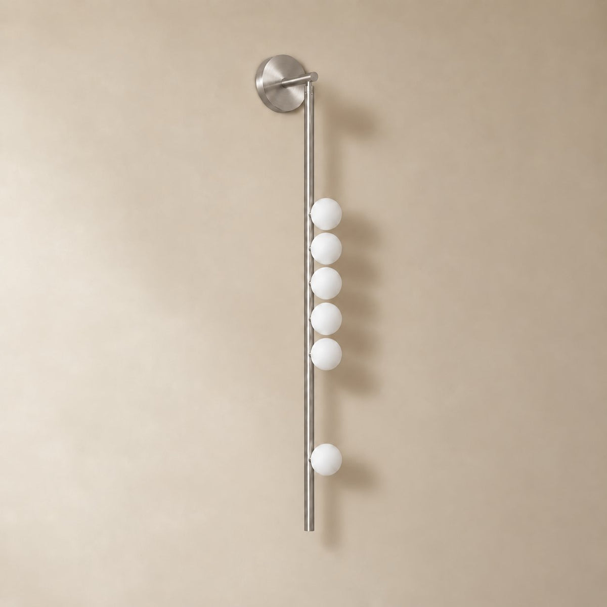 Vouga glass tube wall sconce in brushed nickel, 6 heads, 100 cm, unlit on a plain plaster wall.