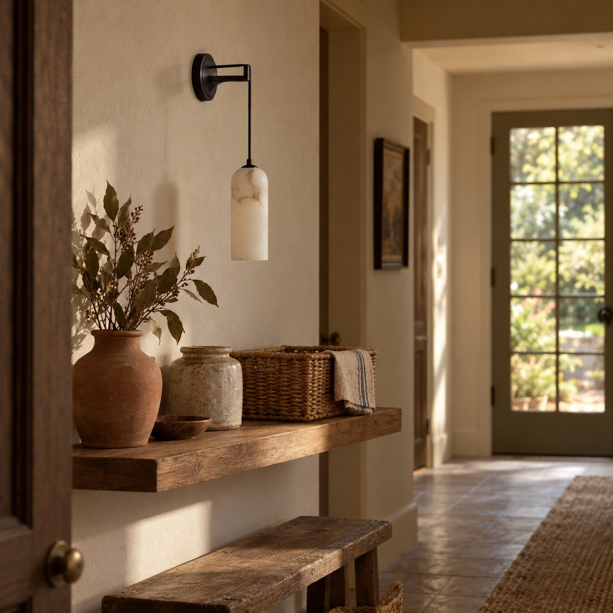 Zêzere black arc sconce with a hanging alabaster cylinder shade above a hallway console table.
